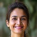 Portrait of Maya, a warm and experienced yoga teacher, smiling gently