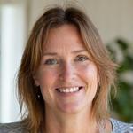 Sarah smiling, representing improved well-being from yoga